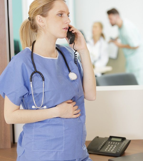 Image of pregnant vet or nurse talking on the phone